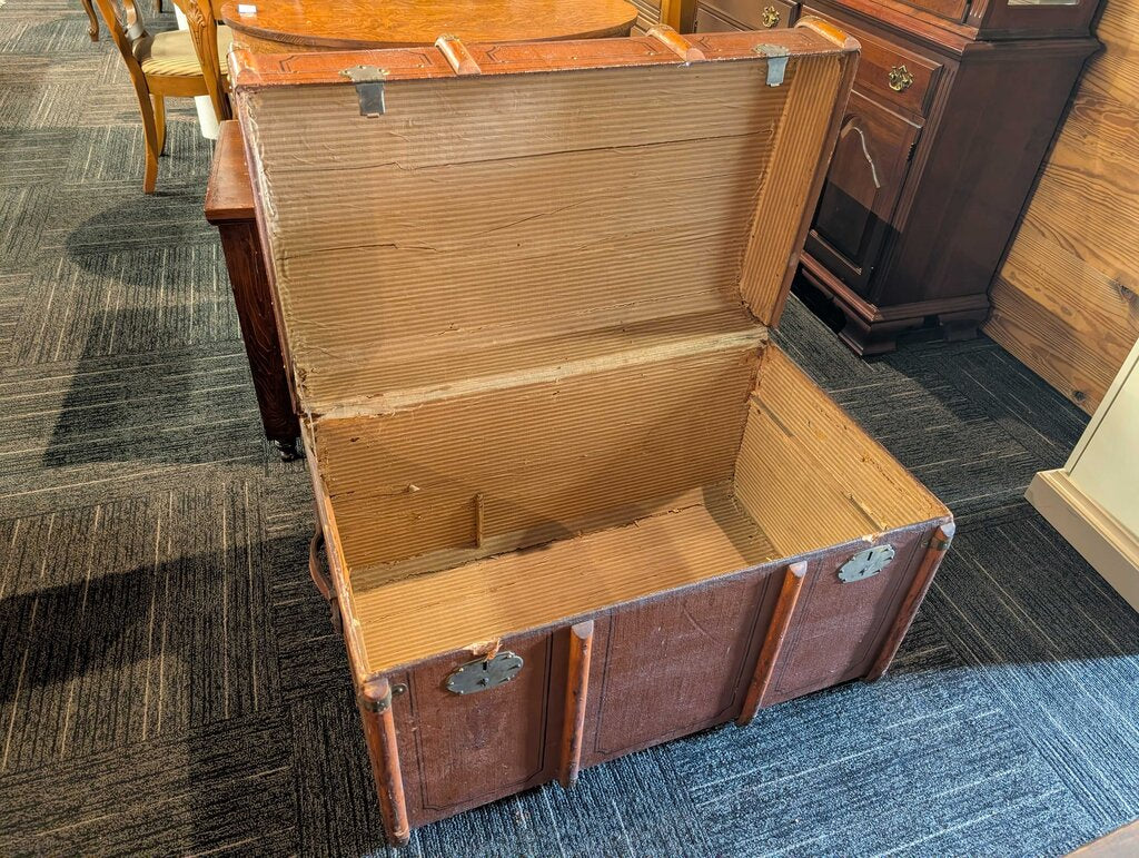 Antique Steamer Trunk / Travel Chest Antique steamer trunk featuring a brown textured exterior with decorative black line detailing, wood slat reinforcements, brass-tone corner and strap hardware, and two front latches. The interior retains its original s
